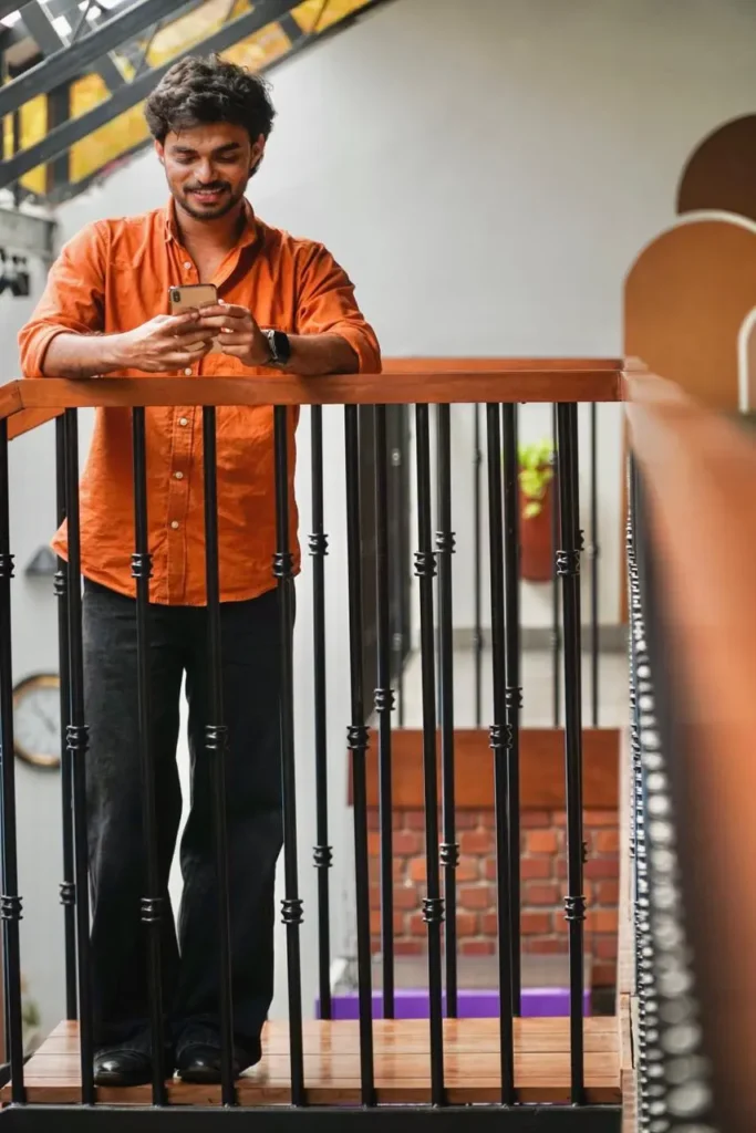 Best freelance digital marketer in Abu Dhabi working remotely using a smartphone in a creative workspace